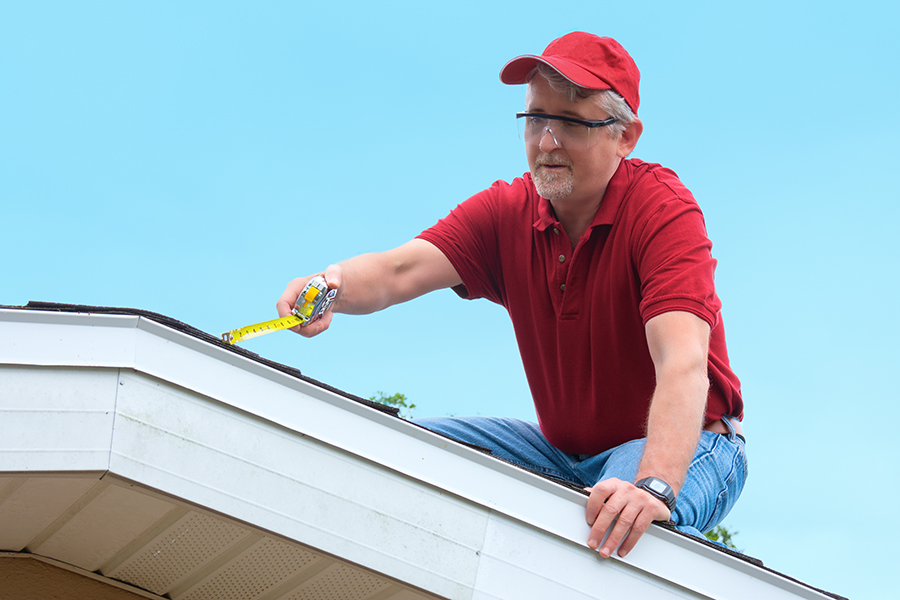 Experienced roofing professional measuring roof dimensions in Fredericksburg, VA